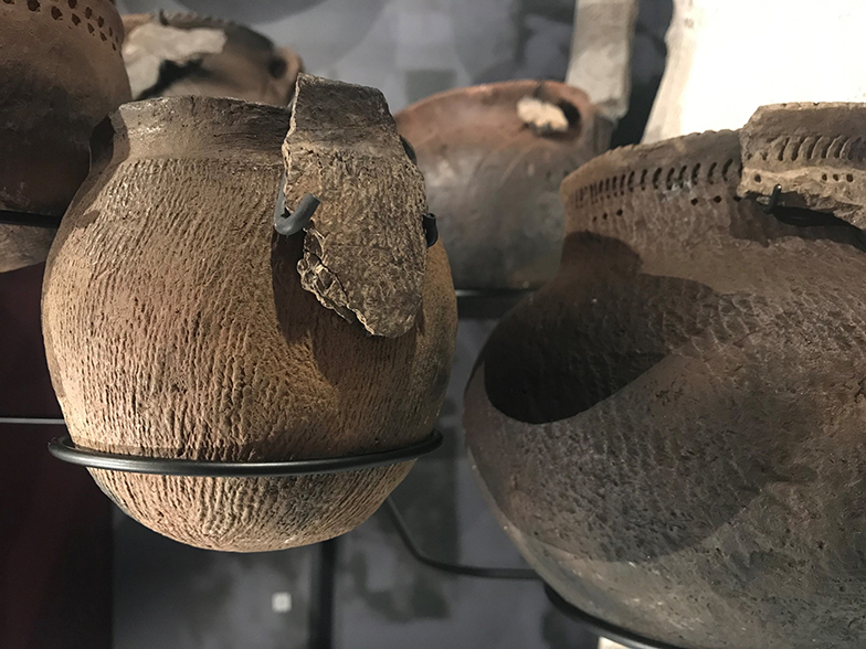 Brown ancient pots on display in a museum
