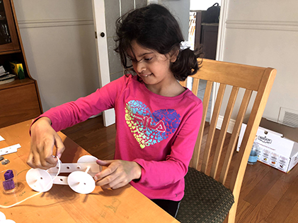 A student builds a car out of paper and straws